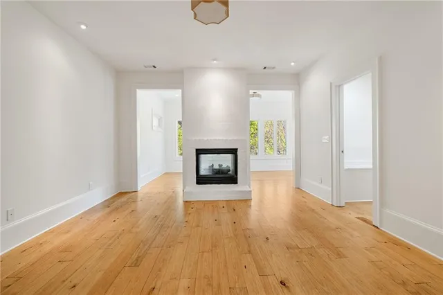 an empty room with wooden floor and fireplace