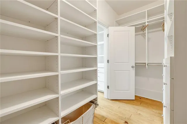 a view of a hallway with wooden floor and windows