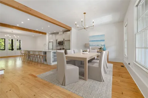 a dining hall with stainless steel appliances a dining table chairs and chandelier