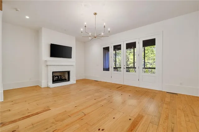 a view of an empty room with a fireplace and a window