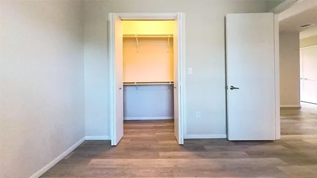 an empty room with closet and a window