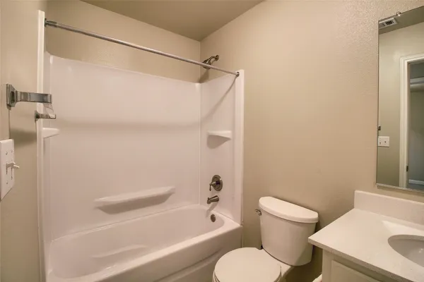 a white toilet sitting next to a bath tub