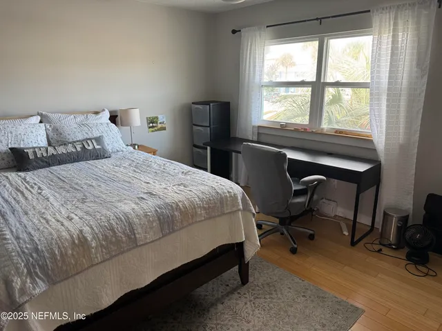 a bedroom with a bed a table and a large window