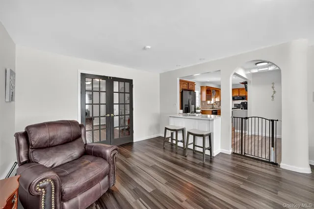 a living room with furniture a flat screen tv and a wooden floor
