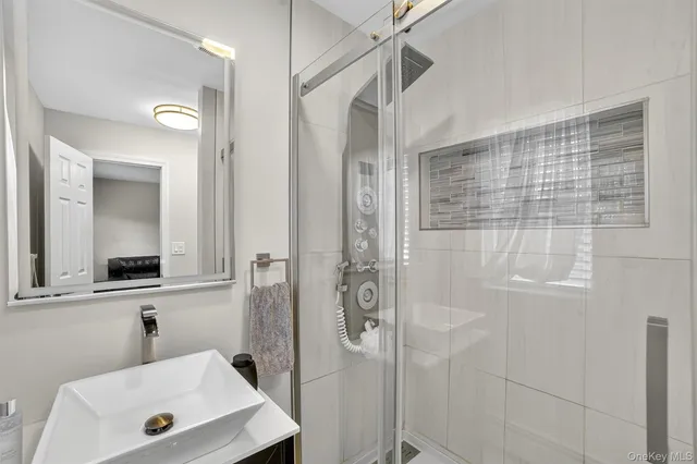 a bathroom with a shower a sink and a mirror