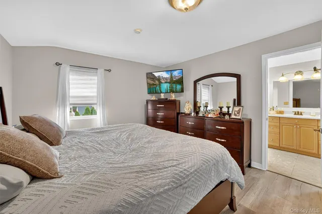 a bedroom with a bed and a large window with the dresser