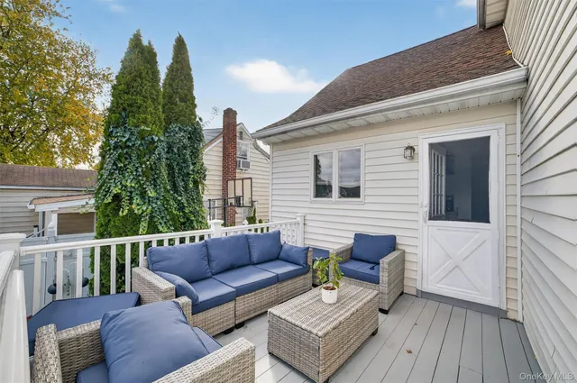 a view of a deck with couches table and chairs with wooden floor and fence