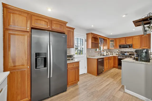 a kitchen with stainless steel appliances granite countertop a refrigerator and a stove top oven