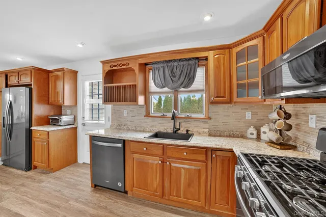 a kitchen with stainless steel appliances granite countertop a sink stove and refrigerator