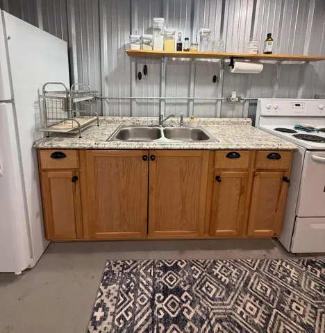 a kitchen with granite countertop a sink and a stove