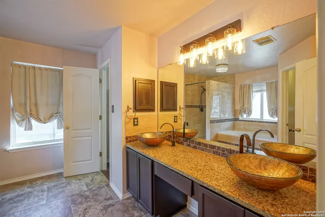 a bathroom with a granite countertop sink and a mirror