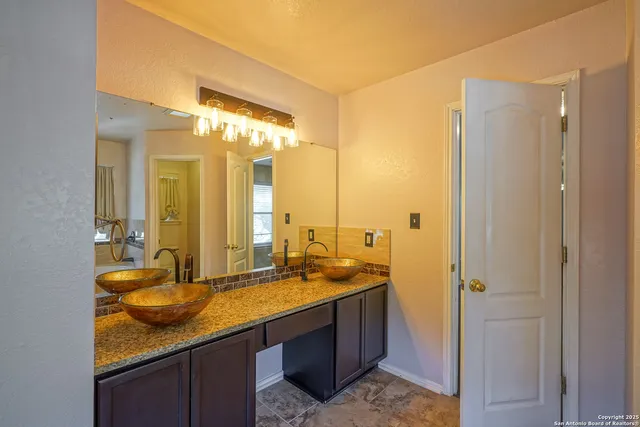a bathroom with a granite countertop sink and a mirror