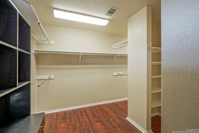 a view of walk in closet with empty racks