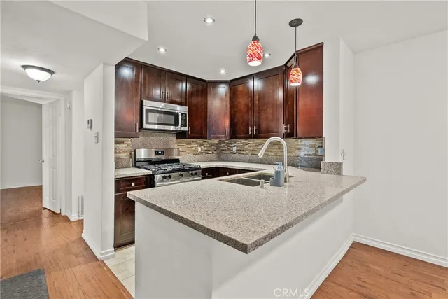 a kitchen with a sink a microwave a stove and refrigerator