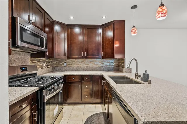 a kitchen with stainless steel appliances granite countertop a sink stove and microwave