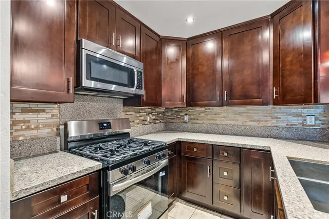 a kitchen with granite countertop wooden cabinets and stainless steel appliances