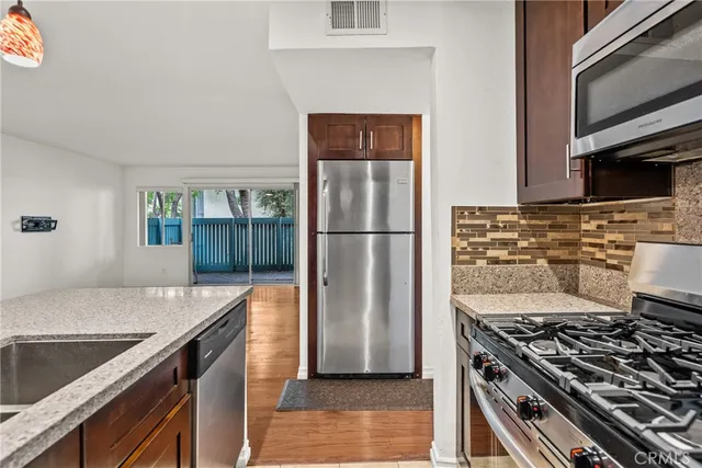 a kitchen with granite countertop a stove and a refrigerator