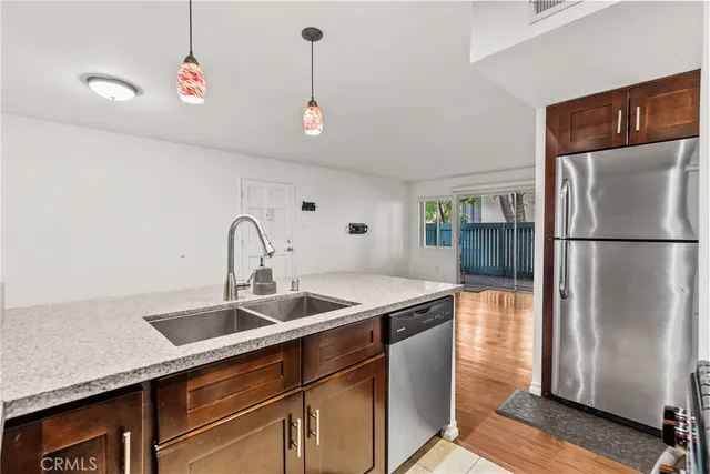 a kitchen with stainless steel appliances granite countertop a refrigerator and a sink