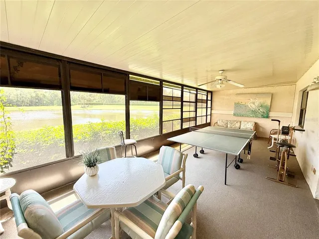 a dining room with furniture and a floor to ceiling window
