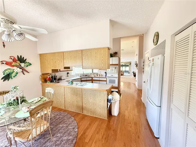 a living room with stainless steel appliances kitchen island granite countertop furniture and a wooden floor
