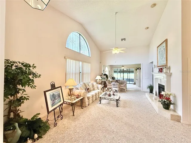 a living room with fireplace furniture and a large window