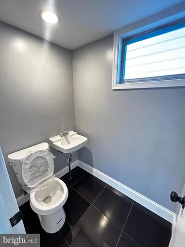 a bathroom with a toilet a sink and a window