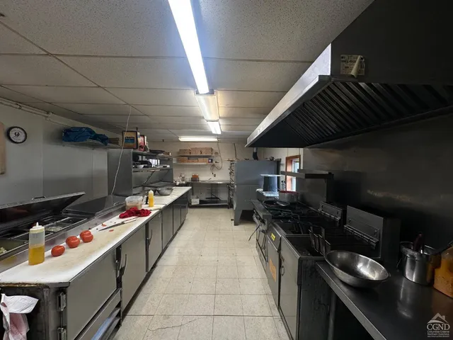 a room with stainless steel appliances kitchen island granite countertop a sink and a stove