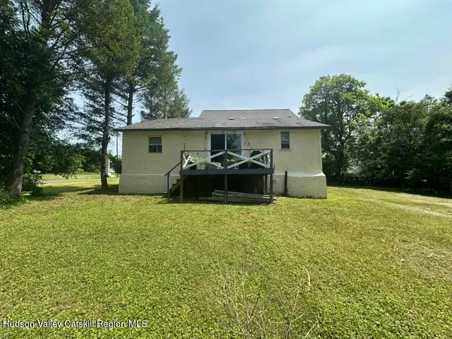 a view of a house with backyard and trees