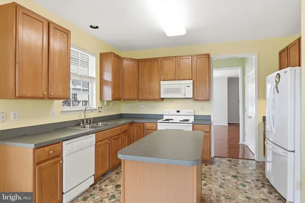 a kitchen with a sink a refrigerator a stove and cabinets