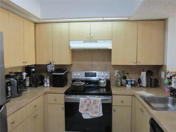 a kitchen with a sink a stove cabinets and black appliances