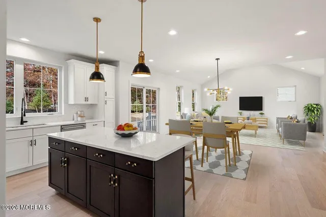 a kitchen with a sink a counter top space and living room view