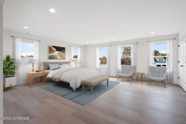 a spacious bedroom with a bed couch and windows