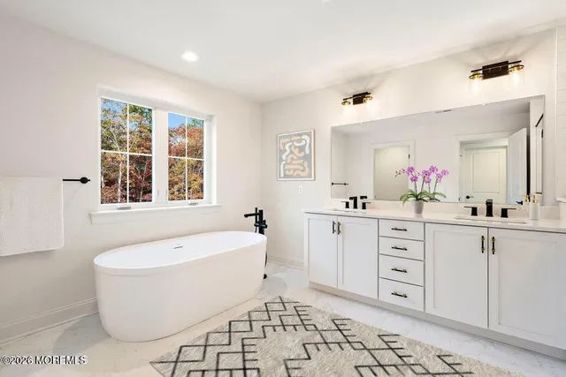 a spacious bathroom with a bathtub sink and mirror
