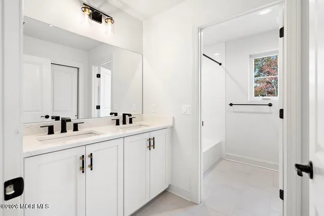 a bathroom with a sink a toilet a shower and a mirror