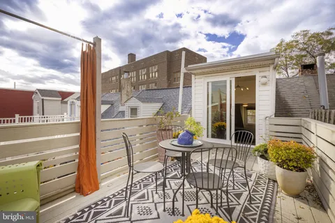 a view of a balcony with dining table and chairs