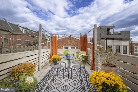 a view of balcony with table and chairs and potted plants