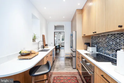 a large kitchen with a lot of cabinets a stove and chairs