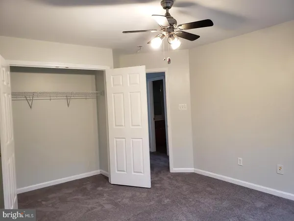 an empty room with a ceiling fan and a fan
