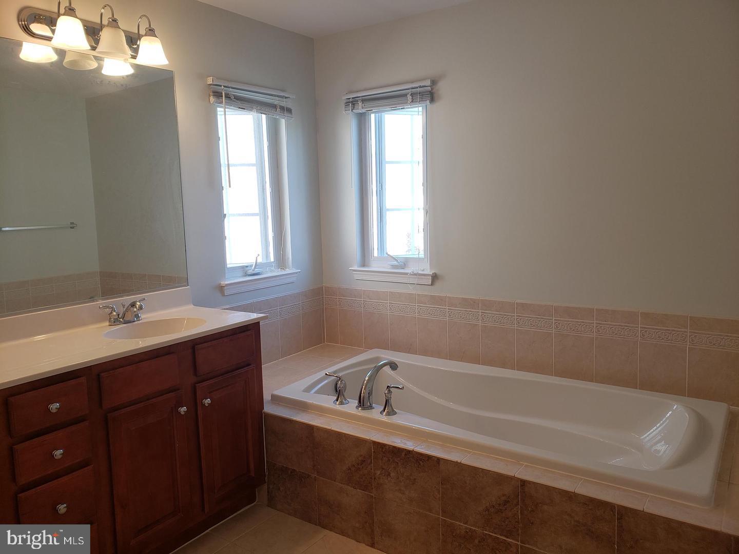 43967 Peony Place California, MD 20619 - Photo 21 of 27 a bathroom with a tub sink and mirror