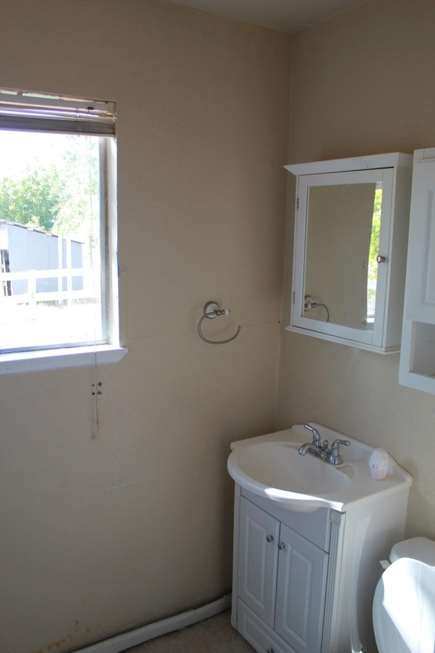 19819 Reeds Creek Road Red Bluff, CA 96080 - Photo 14 of 18 a bathroom with a sink toilet and window