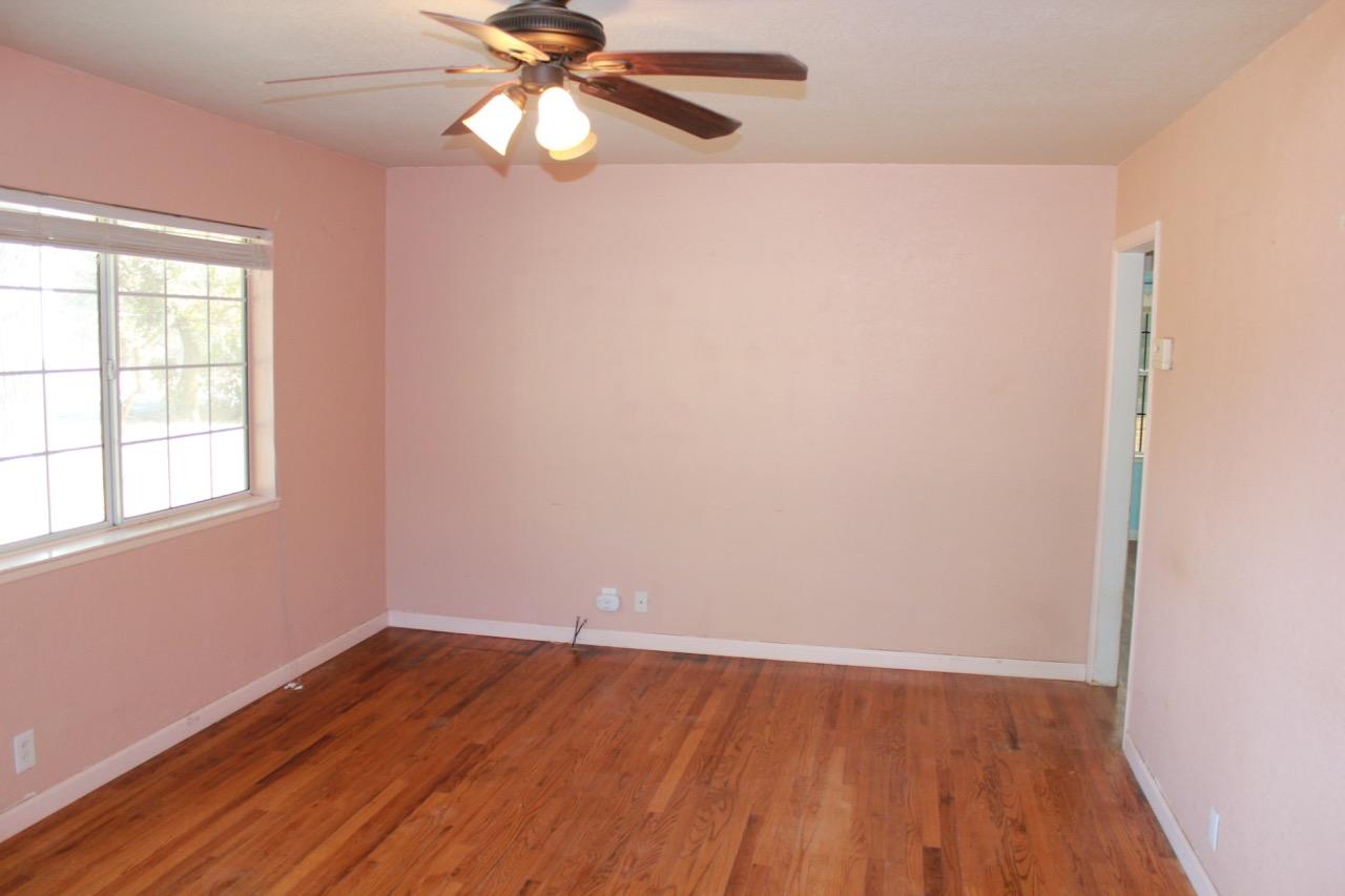 19819 Reeds Creek Road Red Bluff, CA 96080 - Photo 7 of 18 wooden floor in an empty room with a window