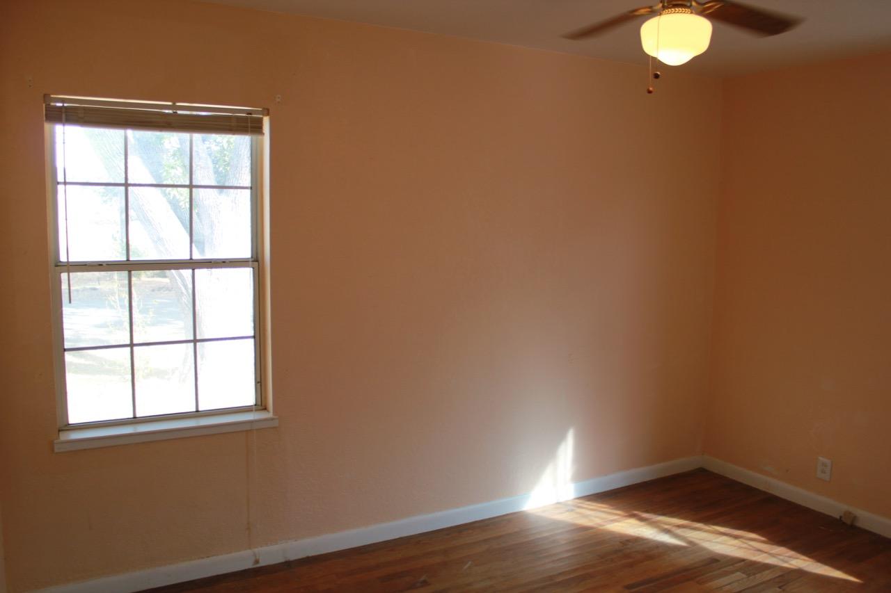19819 Reeds Creek Road Red Bluff, CA 96080 - Photo 10 of 18 an empty room with wooden floor and windows