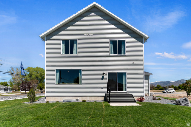 2819 South 710th West, Unit 14 Logan, UT 84321 - Photo 5 of 24 Gable-roofed residence featuring light gray horizontal siding, white trim, and a manicured lawn