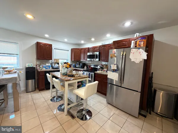 a kitchen with stainless steel appliances granite countertop a refrigerator and a stove top oven