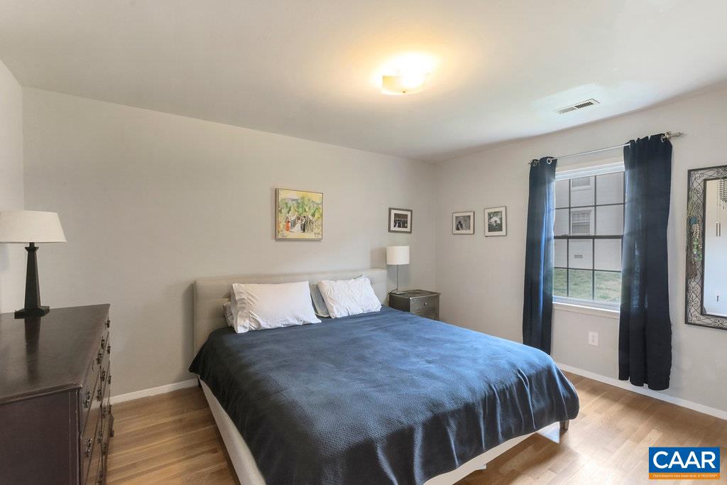 2420 Barracks Place, Unit 4 Charlottesville, VA 22901 - Photo 6 of 12 a bedroom with a large bed and a book shelf