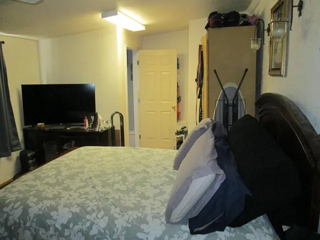 a bed room with a flat tv screen and a dresser
