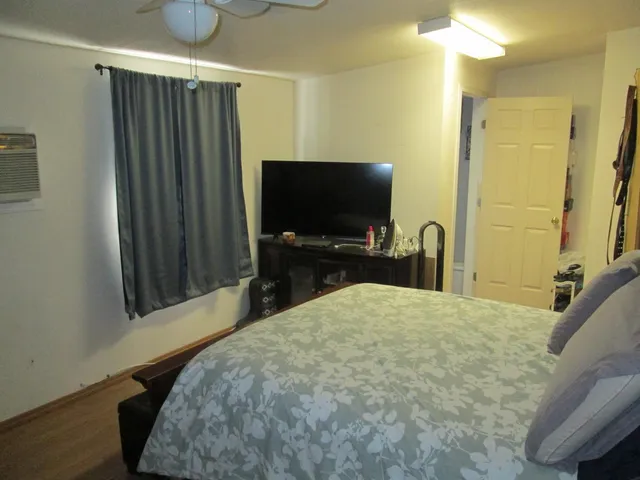 a bedroom with a bed and a flat screen tv