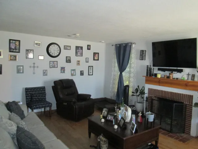 a living room with furniture a flat screen tv and a fireplace