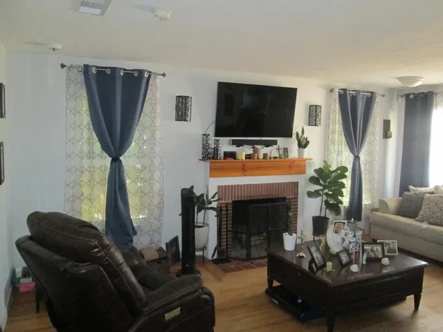 a living room with furniture a fireplace and a flat screen tv