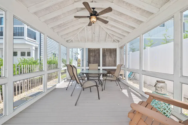 a dining room with furniture a chandelier and a large window